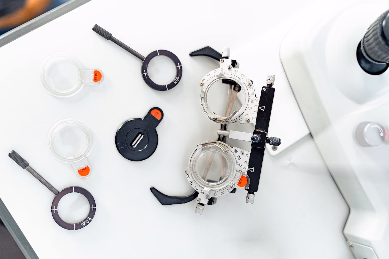 A medical device with multiple rings and a lever is placed on a tablecloth.