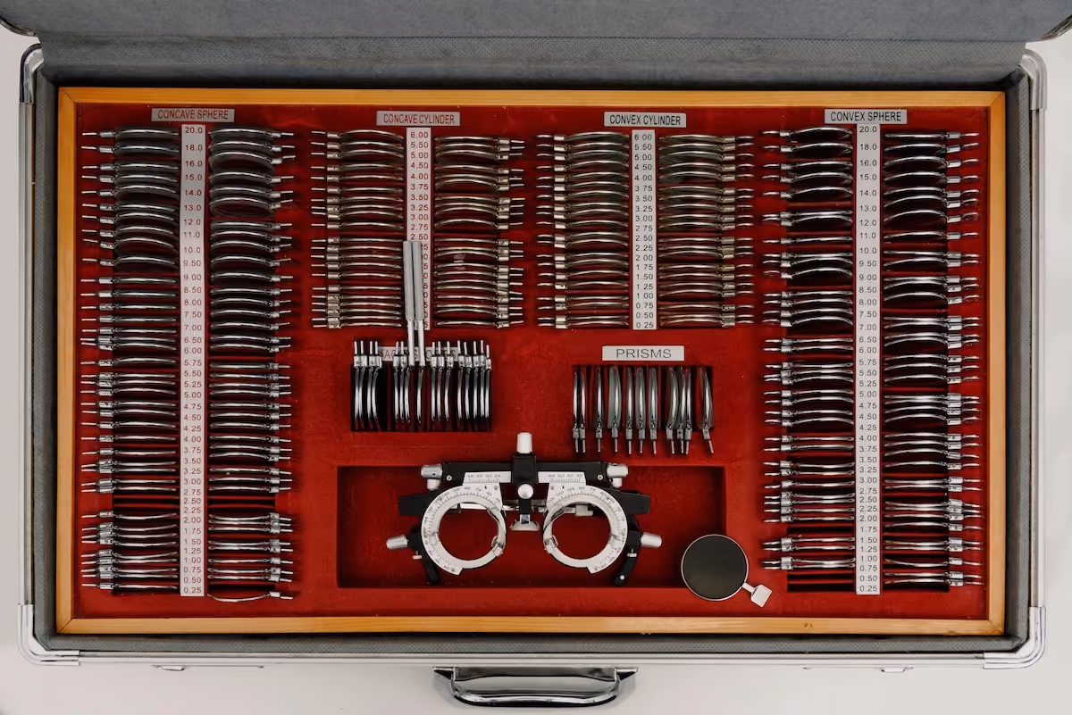 The image is an eye care kit with various eyeglasses and contact lenses arranged neatly within a case.