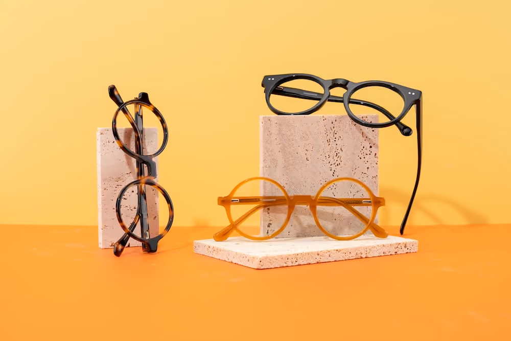 Three pairs of glasses on top of decoration cardboard and an lemon