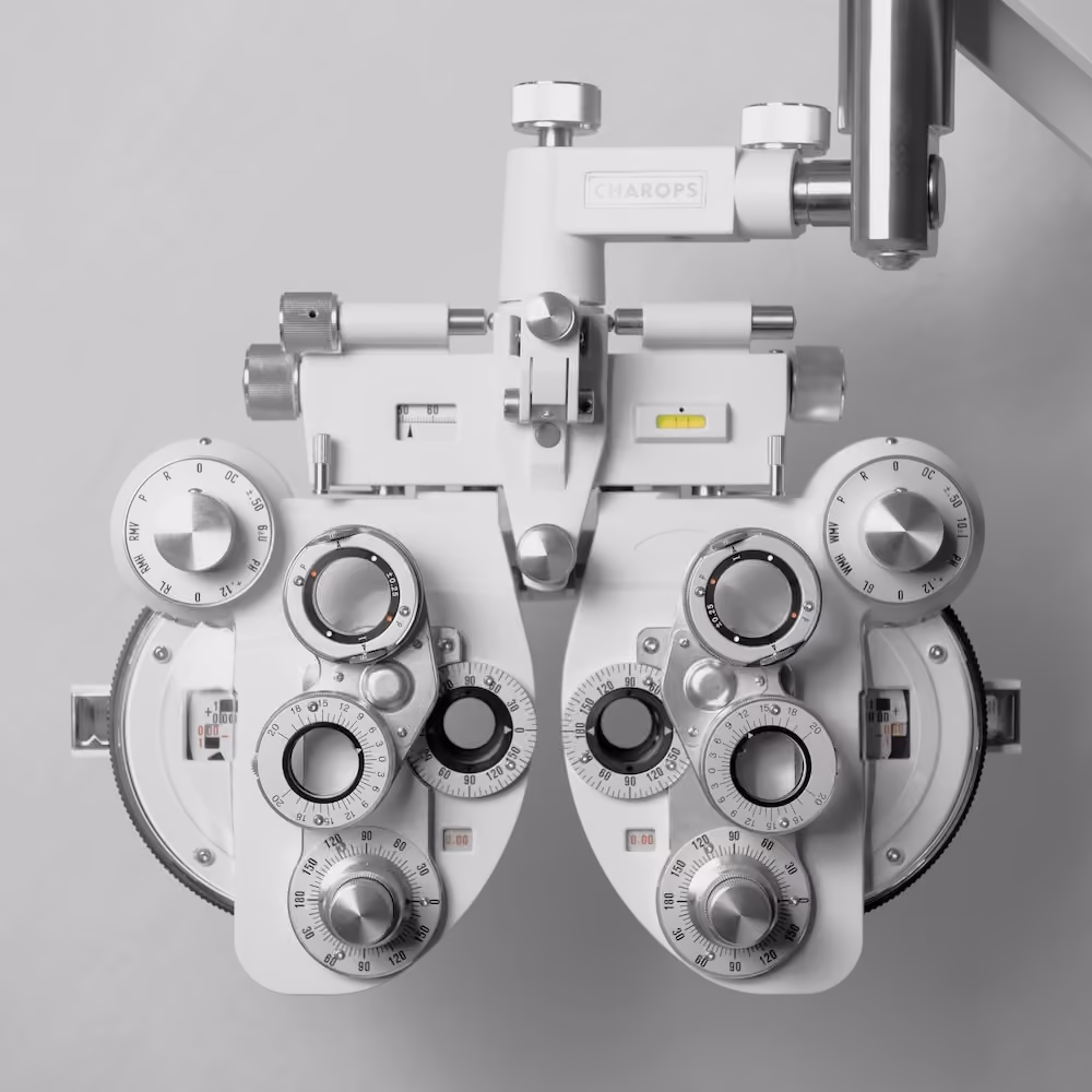 A machine with multiple knobs and a yellow label is mounted on a white wall.
