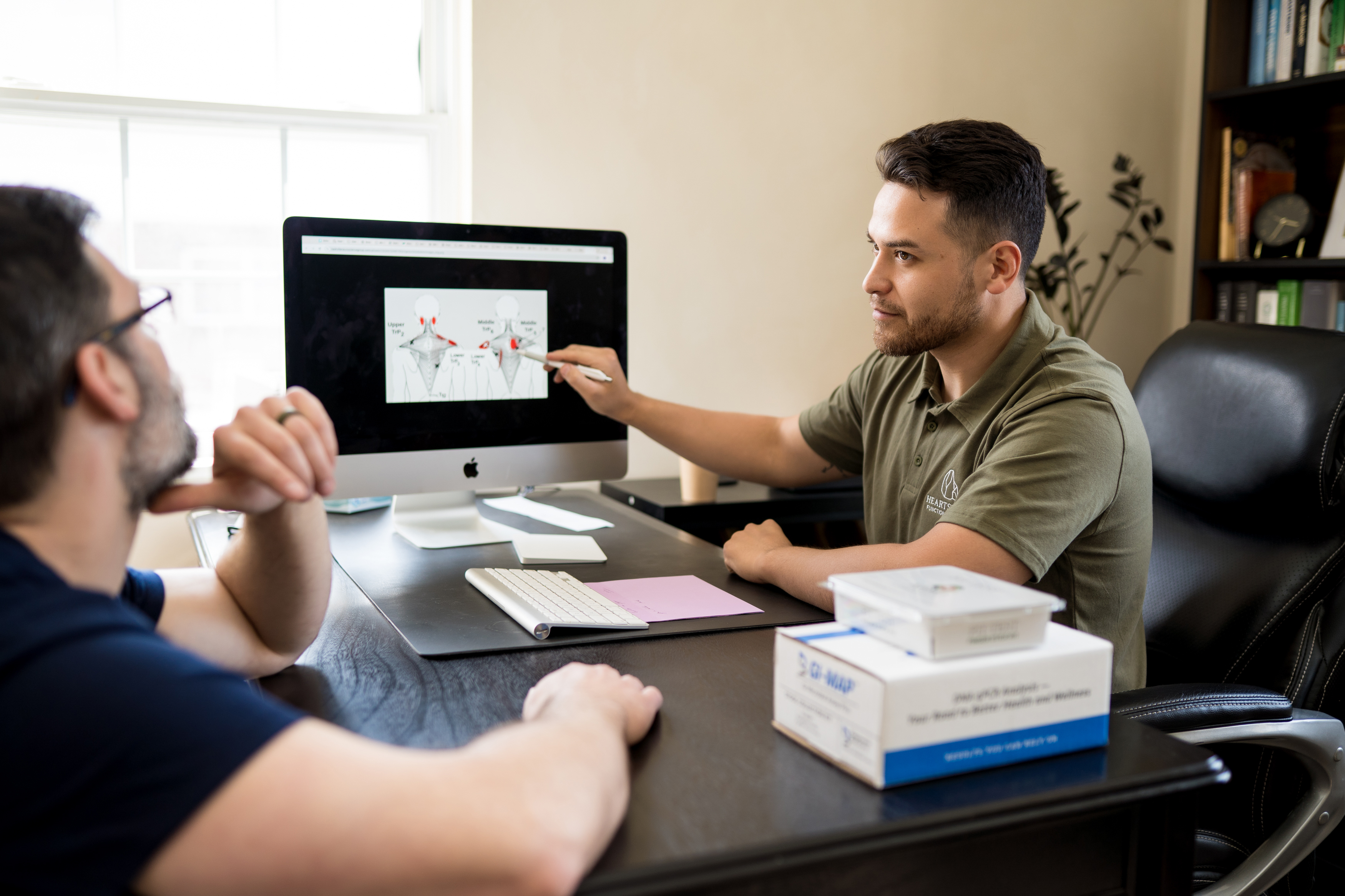 Dr. Adrian showing a patient a report of assessment