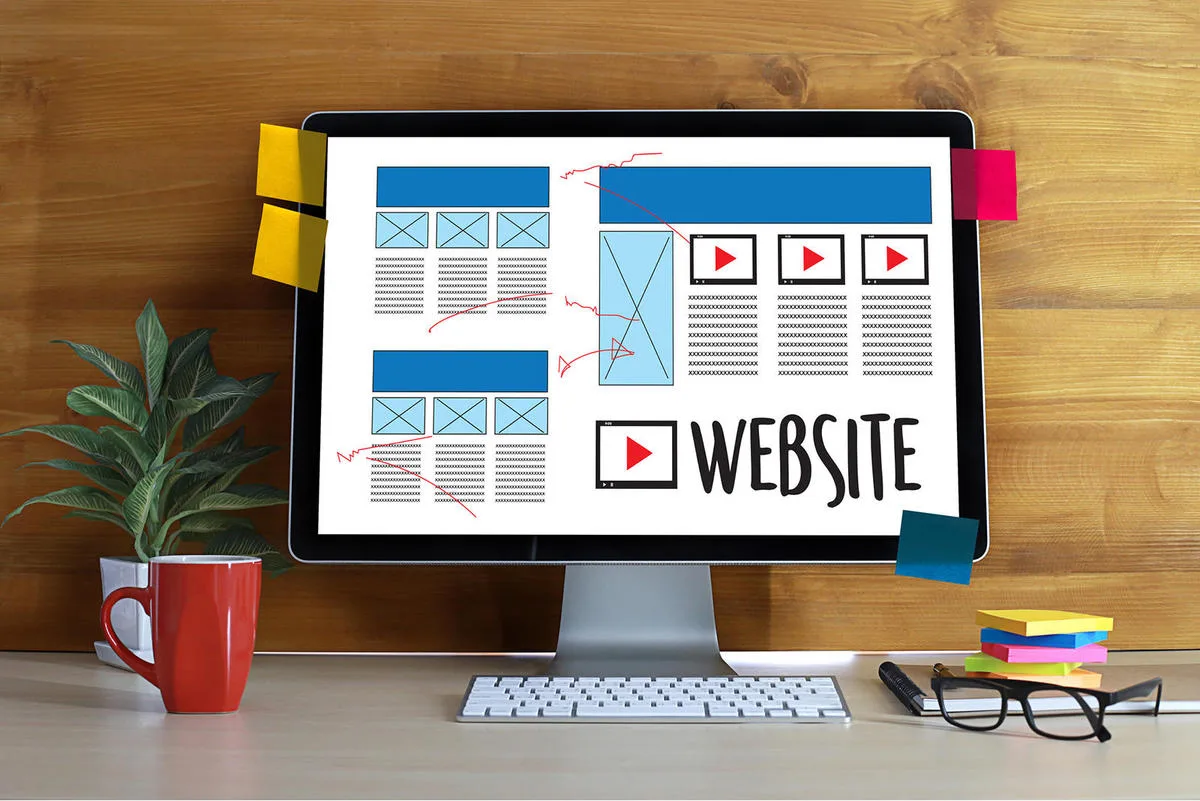 Ondernemer bekijkt websiteontwerp en kostenoverzicht op laptop aan bureau