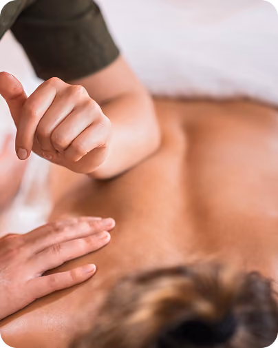 Close-up of a person receiving a massage on their back from a therapist's hands.