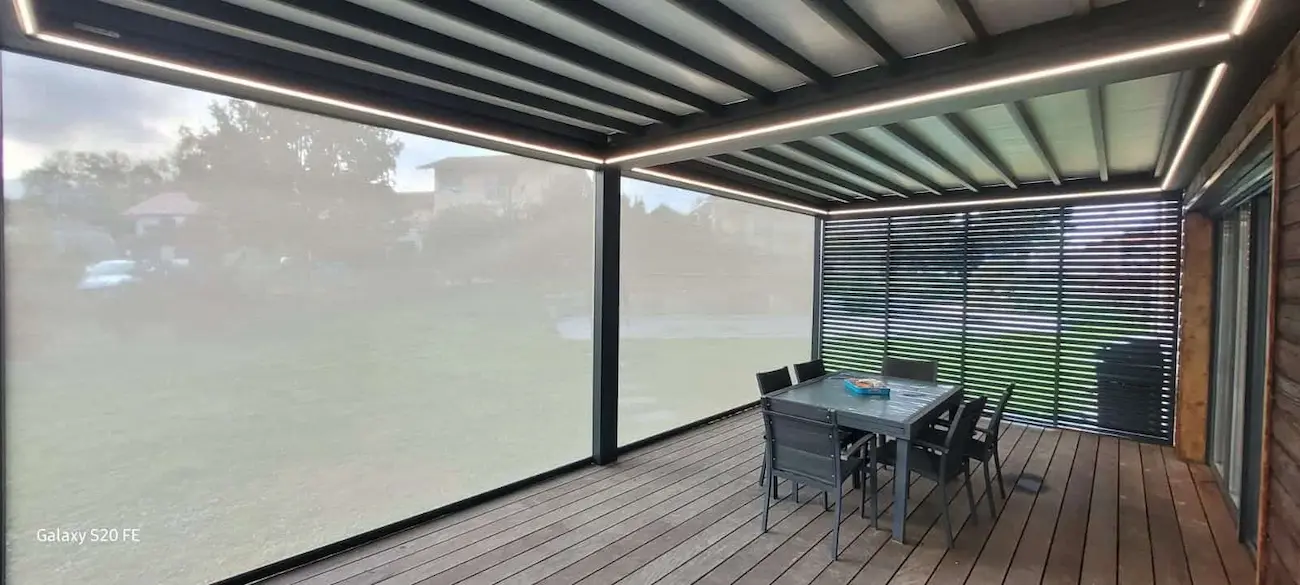 Entrée d'une maison moderne avec portillon en métal noir et chemin pavé sur herbe verte.