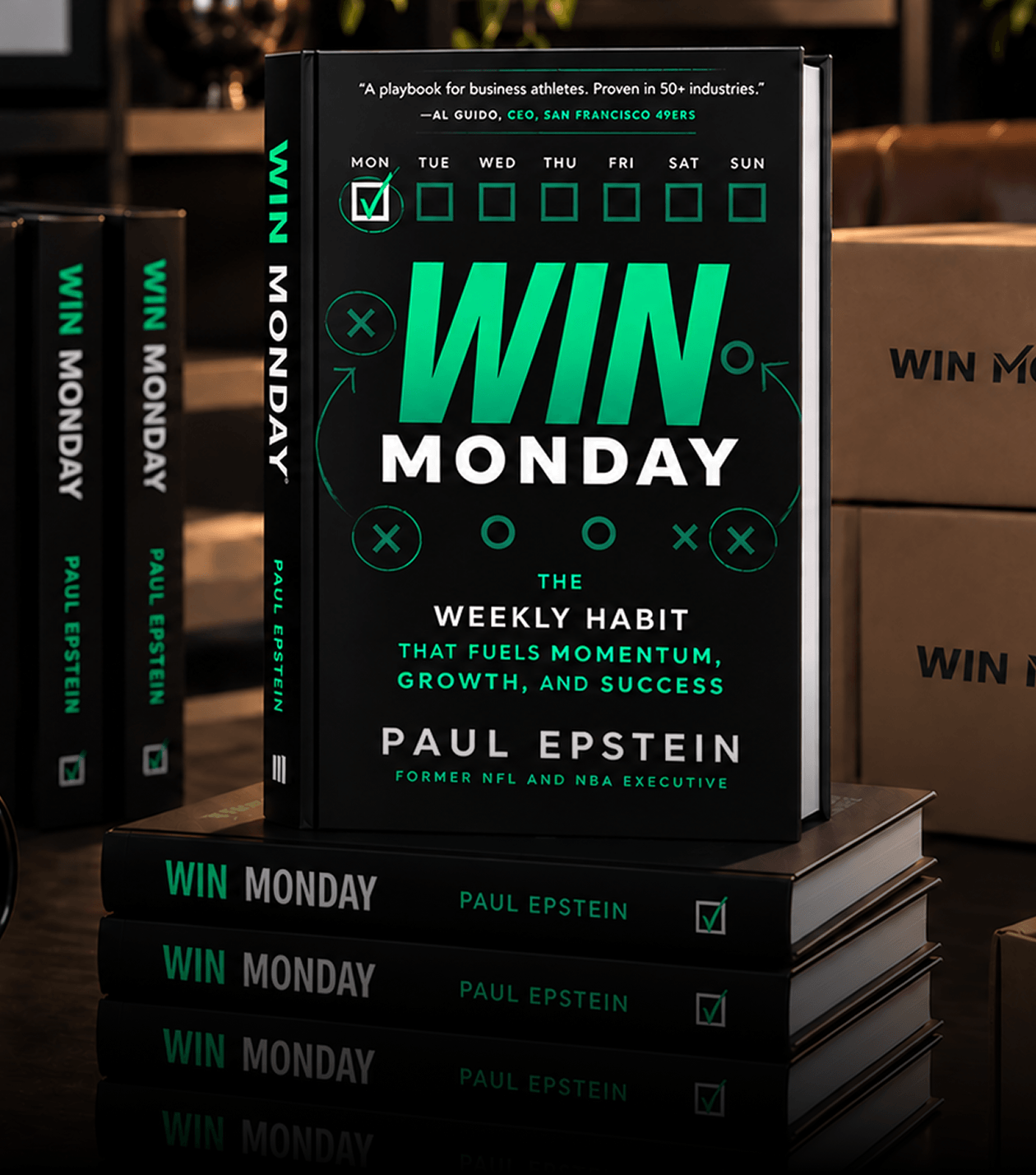 Stack of books titled 'Win Monday' by Paul Epstein displayed with a close-up of the front cover, which highlights the subtitle 'The weekly habit that fuels momentum, growth, and success' and a quote from Al Guido, CEO of San Francisco 49ers. The design includes a weekly checkbox calendar with Monday checked and football play diagram elements.