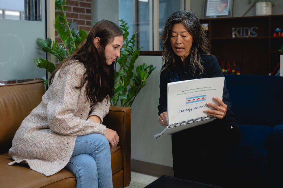 Two women discuss a document in a clinical office setting at Minnesota Craniofacial Center.