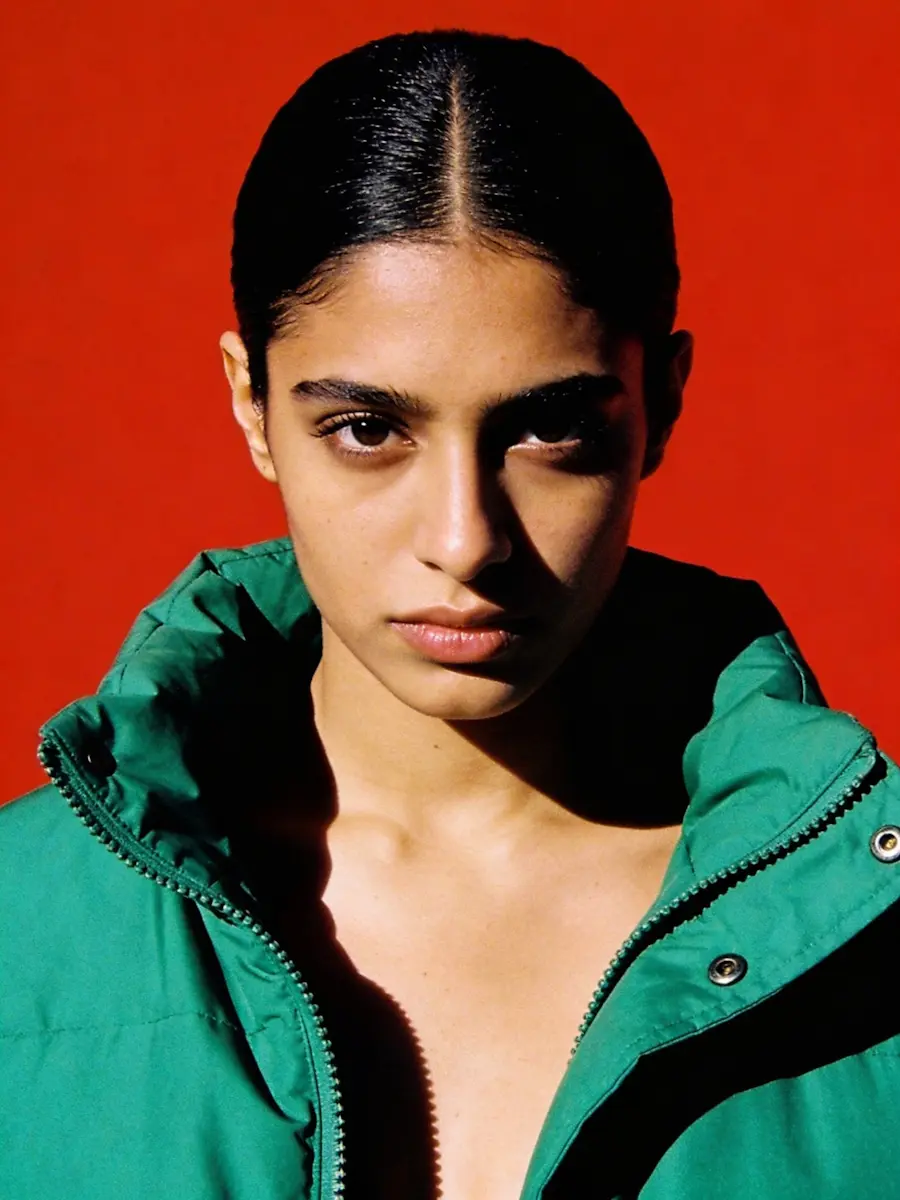 Portrait of woman wearing green jacket with dramatic lighting
