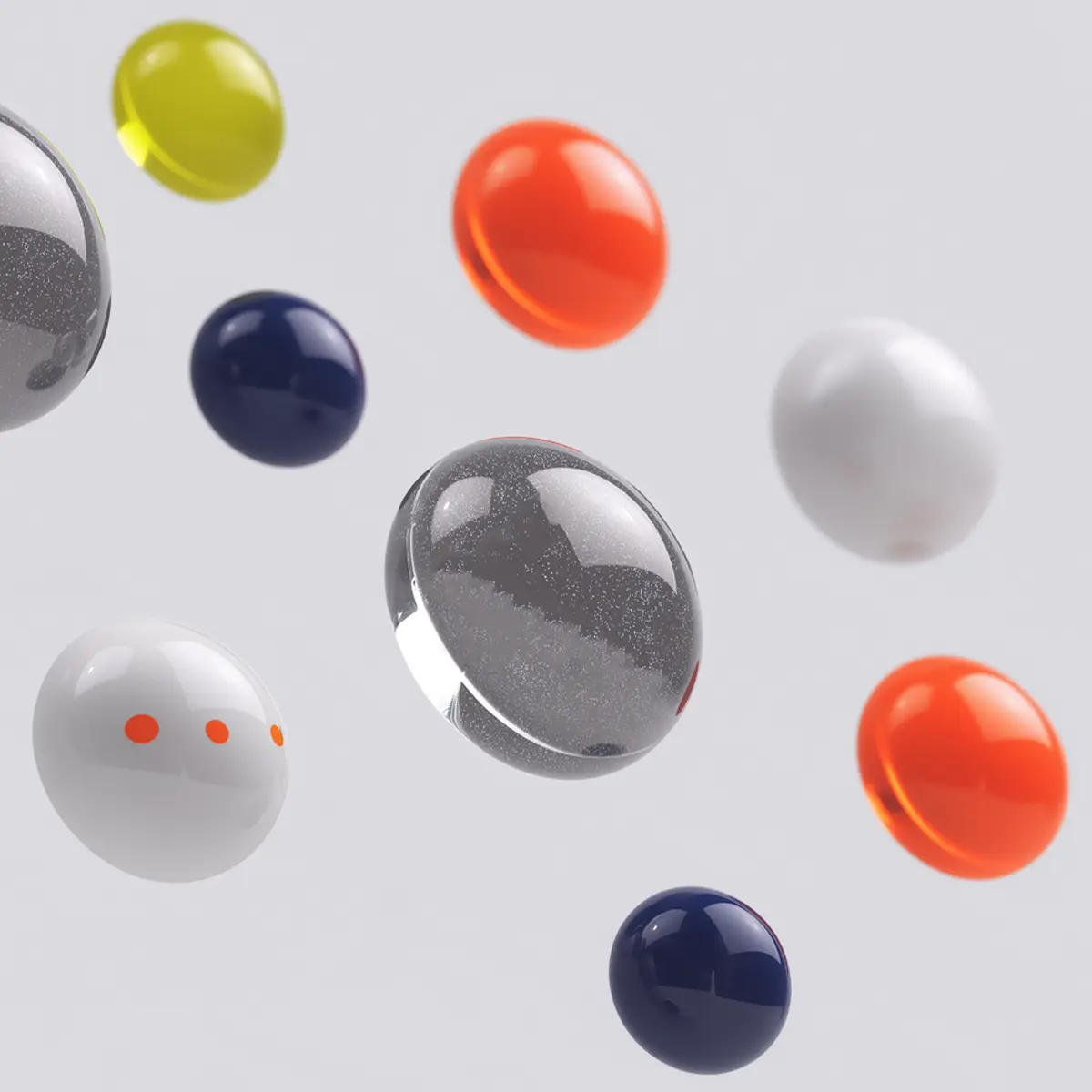 Floating glossy spheres in various colors including orange, navy, yellow, white, and transparent gray.