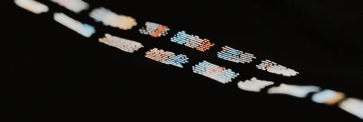 Blurred colorful lines of code or text on a dark background in a diagonal pattern.