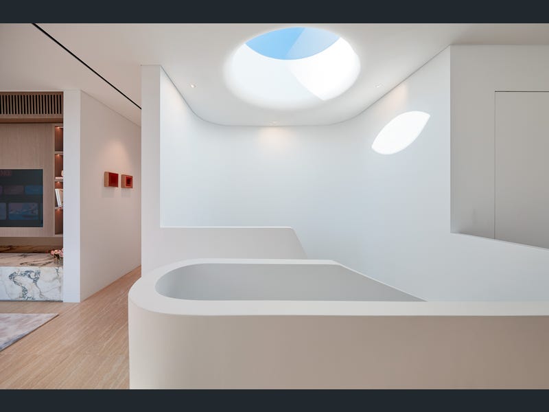 Sculpted bath beneath an oval skylight