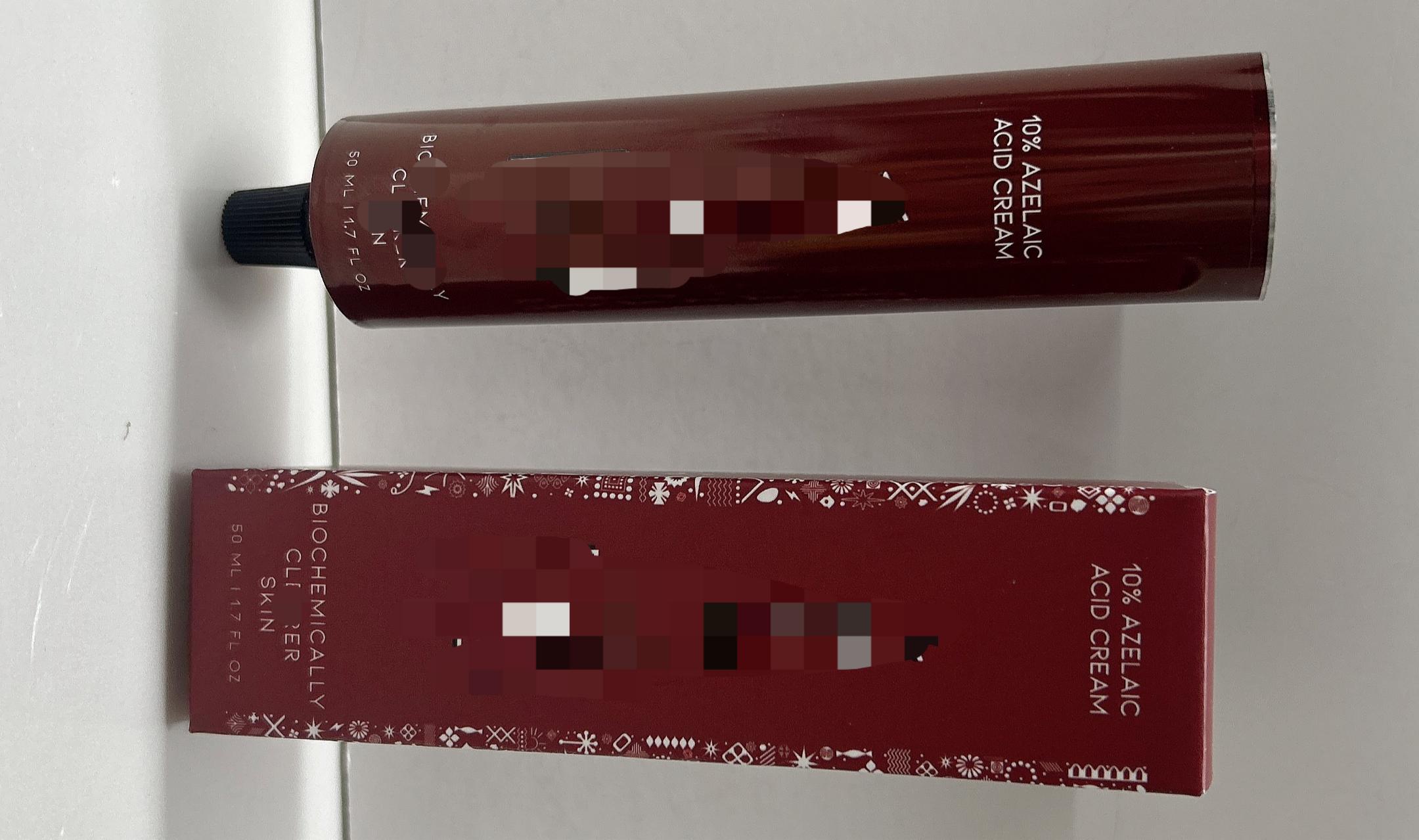 Final approved matte blood-red aluminum tube and matching paper box packaging for the Azelaic Acid Cream