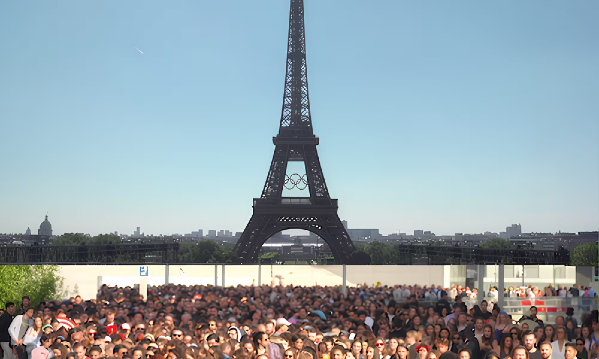 Multitud de turistas frente a la torre Eiffel en París bajo un cielo azul