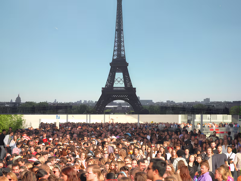 Multitud de turistas frente a la torre Eiffel en París bajo un cielo azul