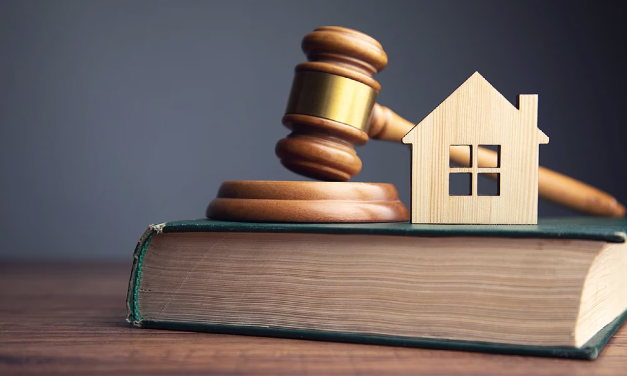Mazo de juez y casa de madera sobre un libro
