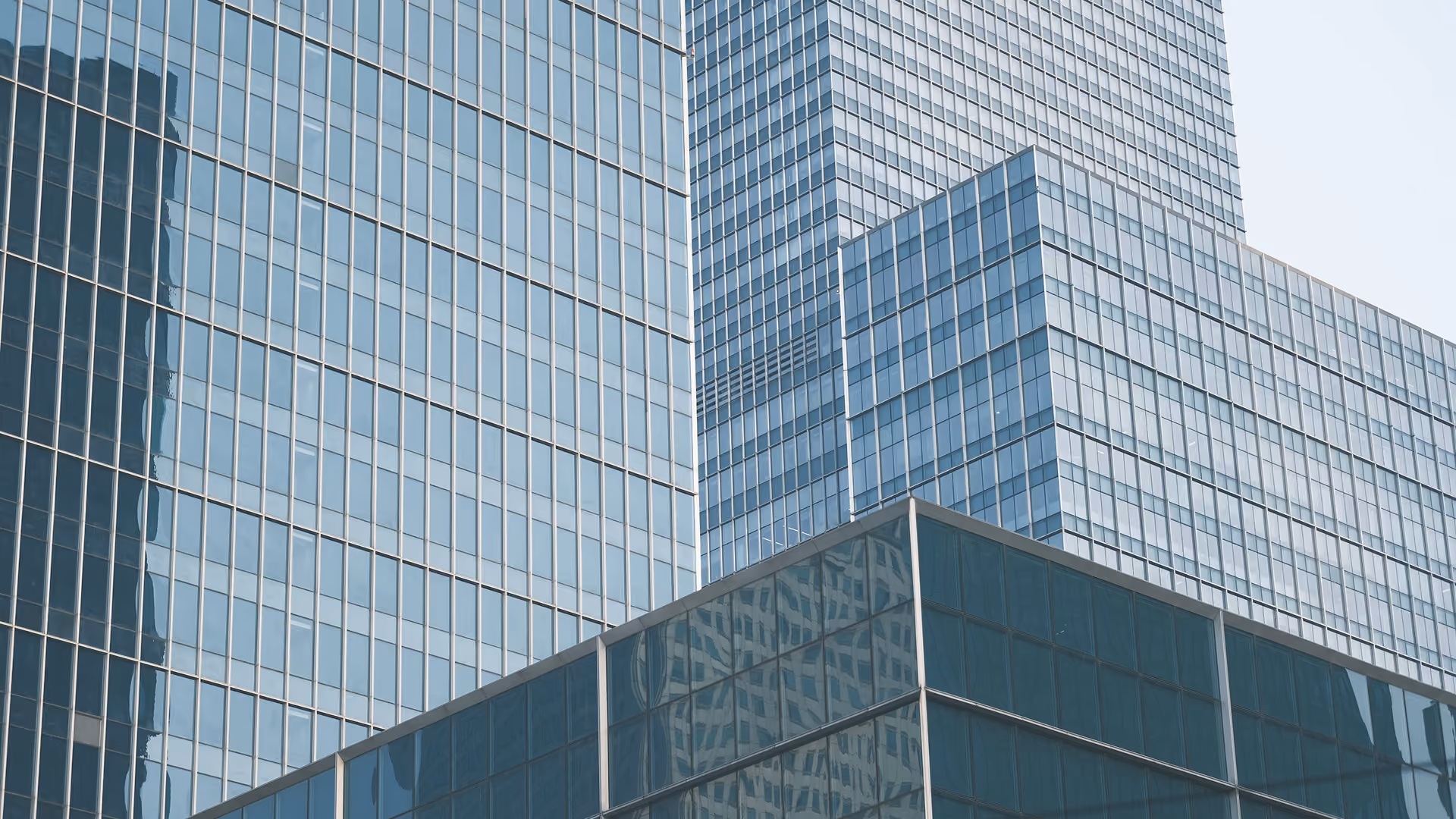 Exterior view of multiple modern glass skyscrapers with reflective windows.