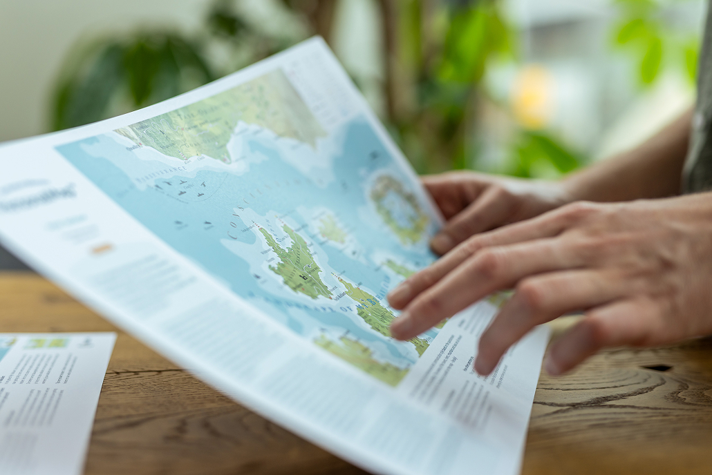 Hand resting on a PersonalMap on a wooden table