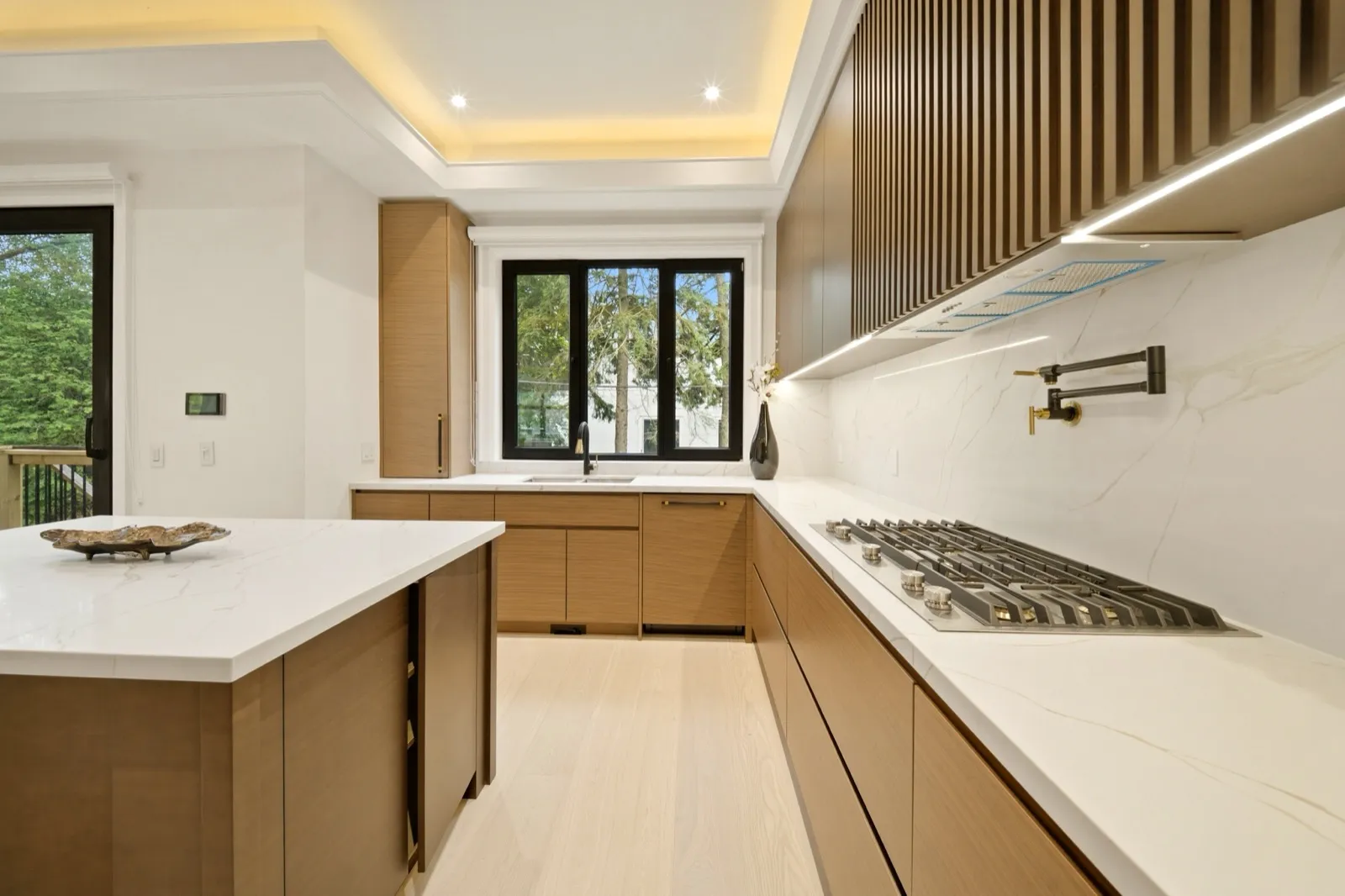 HDR kitchen photo — wood cabinetry, marble backsplash and cove lighting