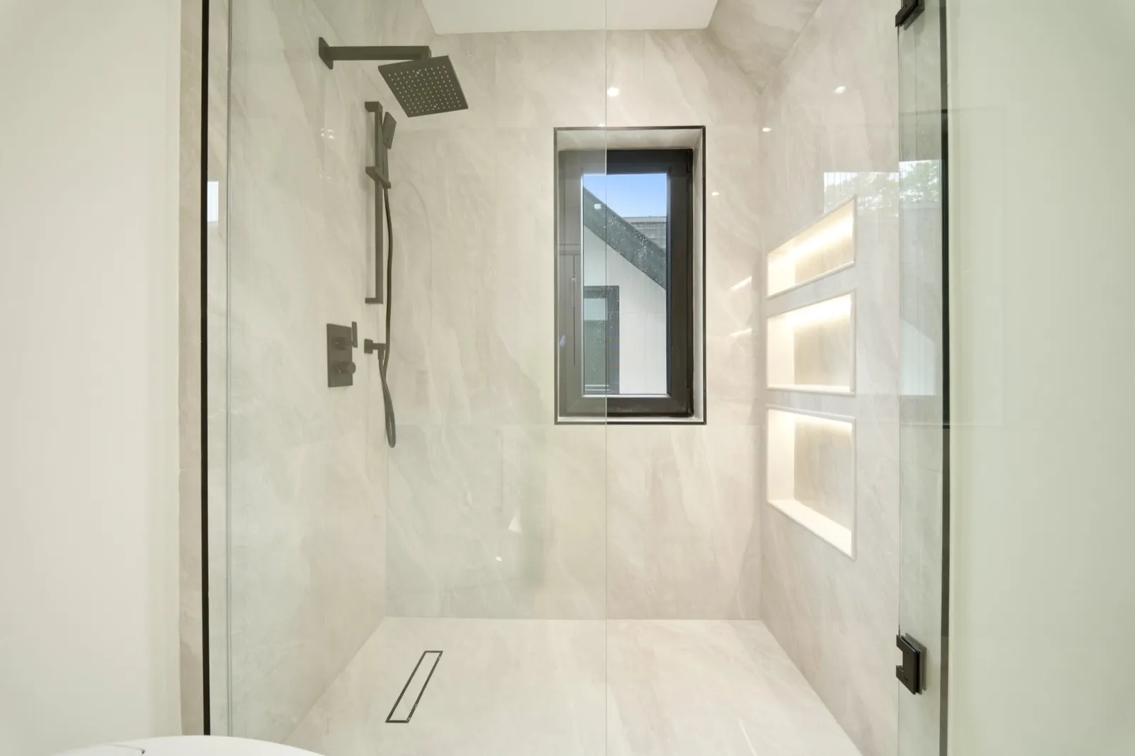 HDR bathroom photo — walk-in rain shower with lit niches