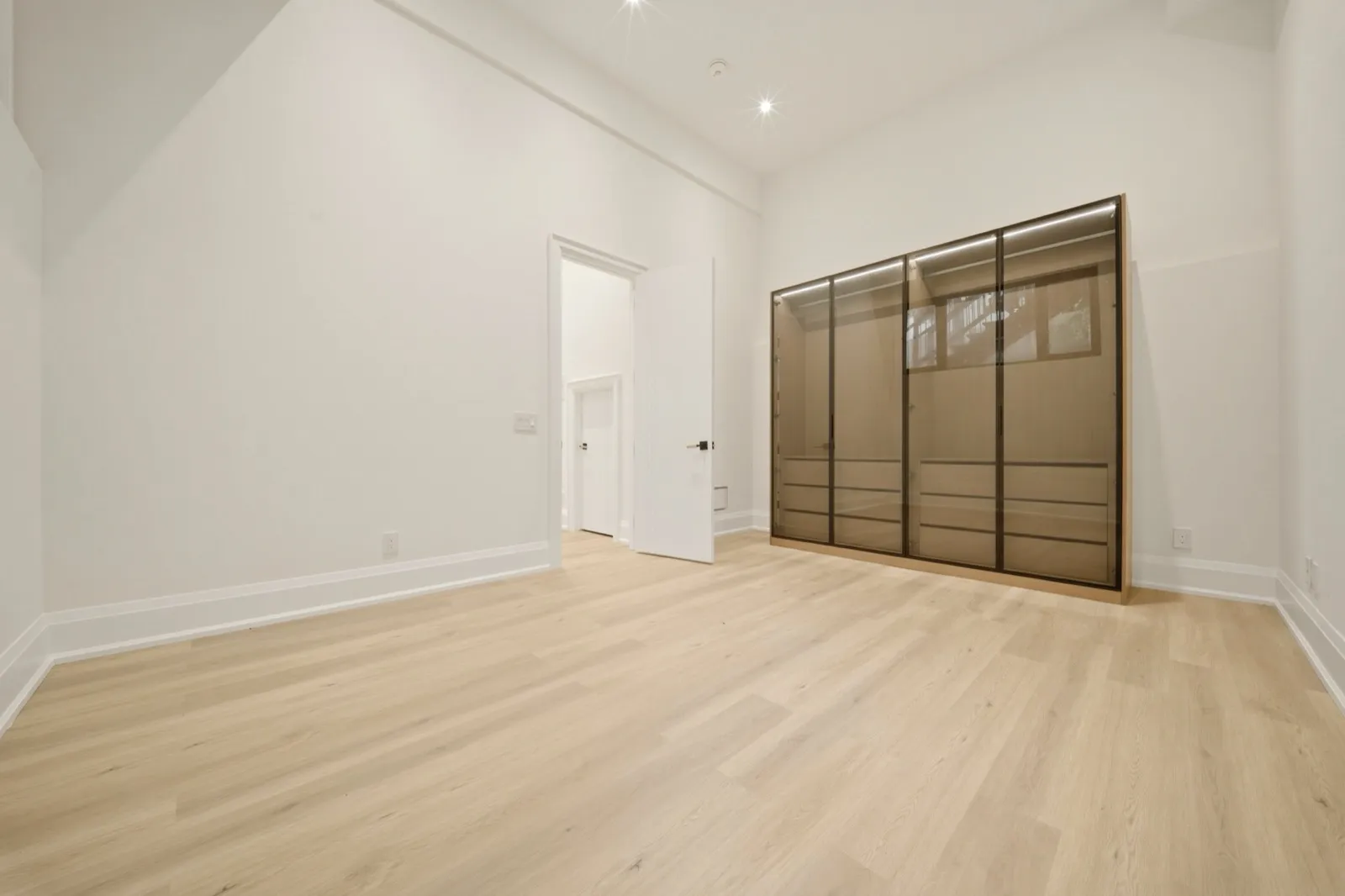 HDR bedroom photo with smoked-glass wardrobe wall