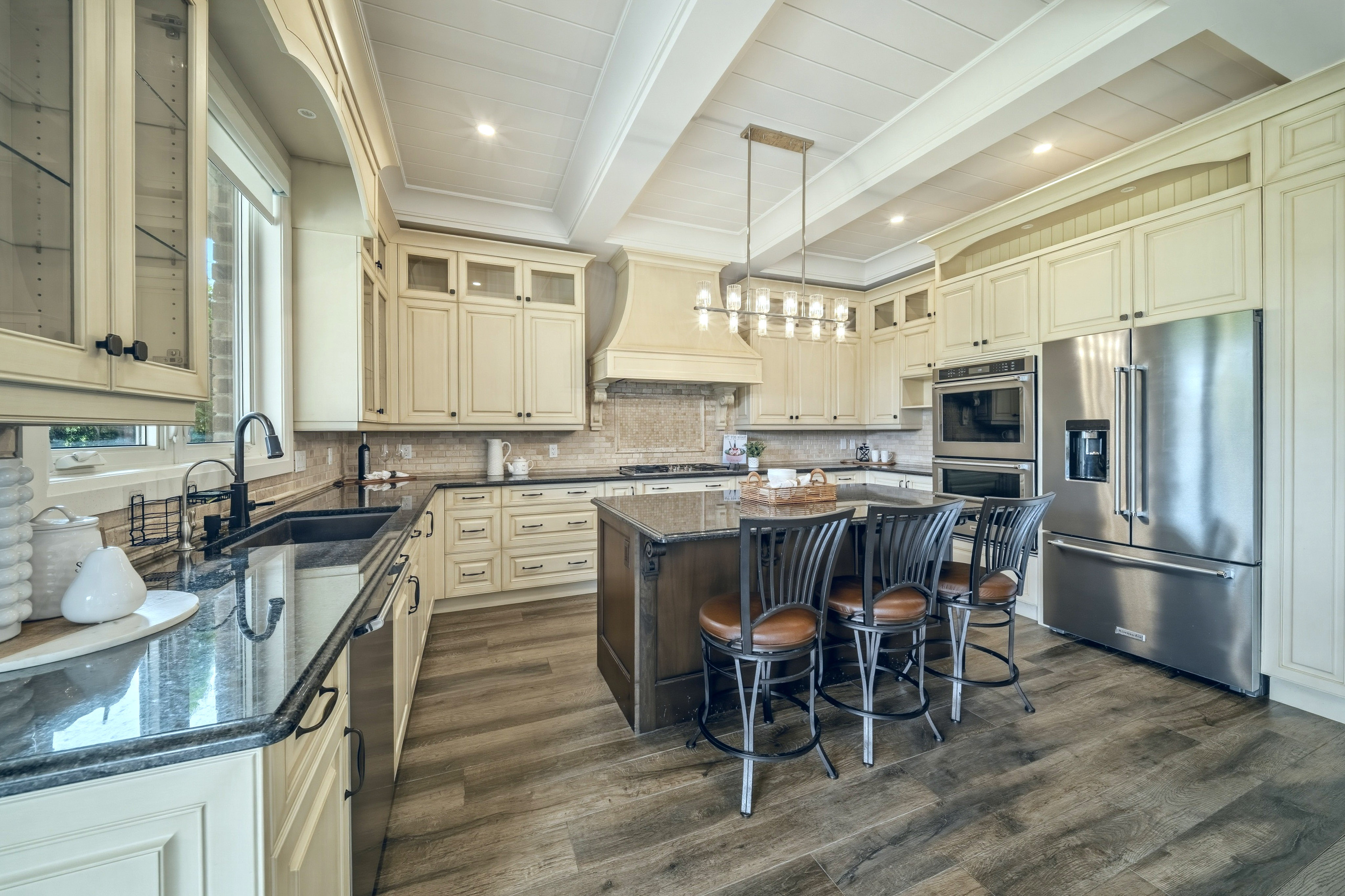 294 Tanbark Road, Niagara-on-the-Lake — kitchen with cream cabinetry, dark granite island and a vaulted plank ceiling