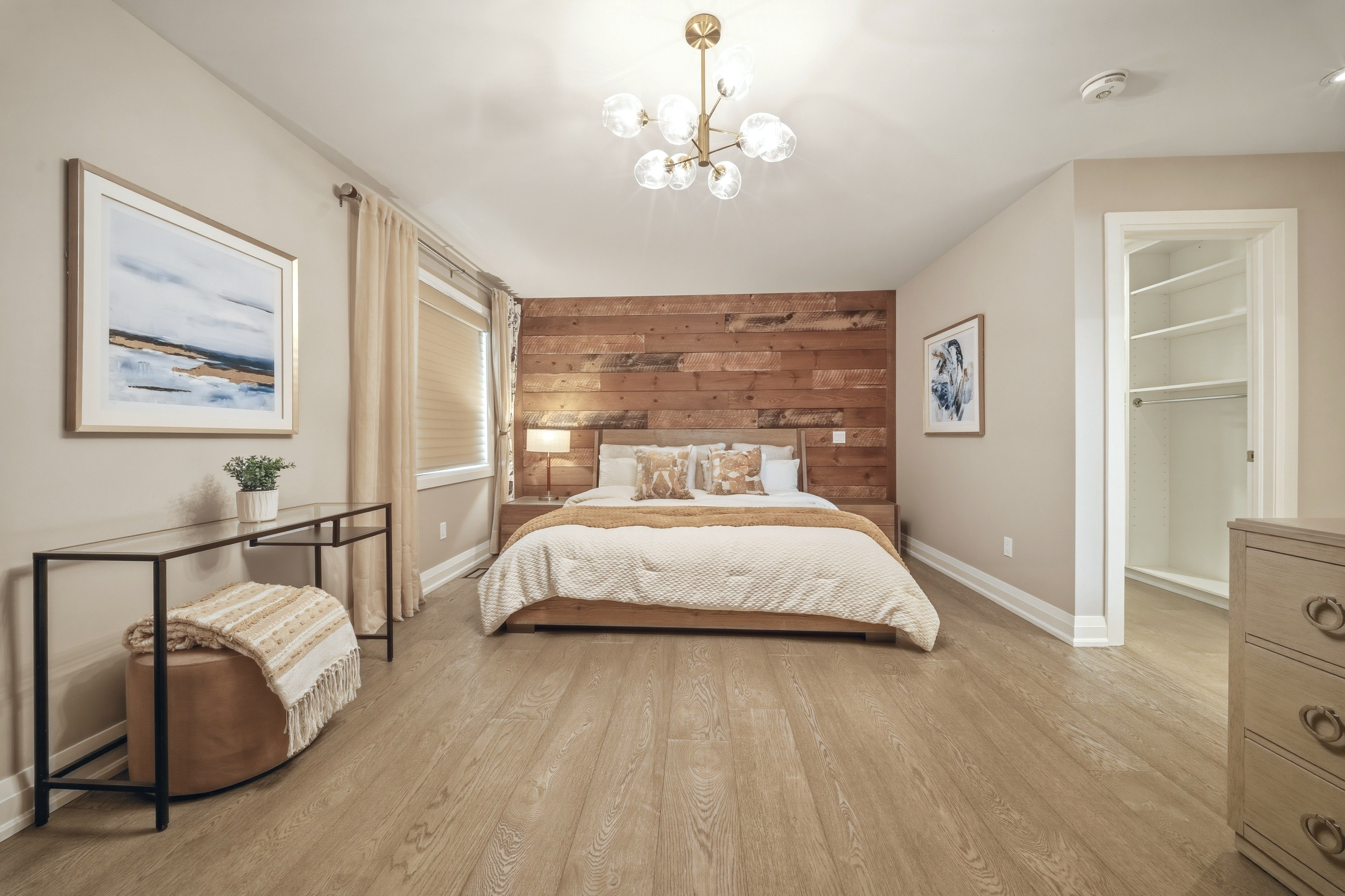 294 Tanbark Road, Niagara-on-the-Lake — primary bedroom with a wood feature wall, chandelier and walk-in closet
