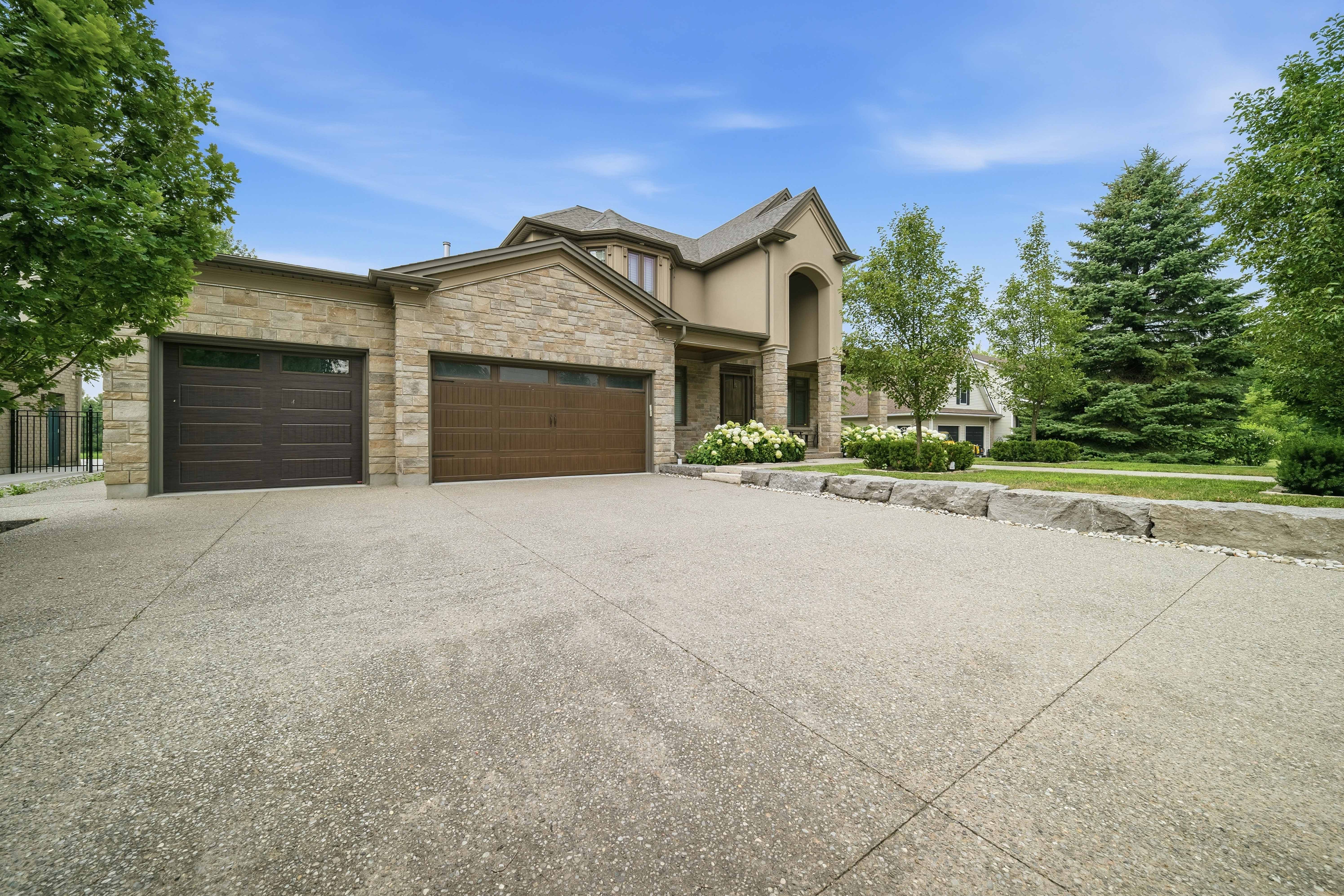294 Tanbark Road, Niagara-on-the-Lake — three-car garage and wide concrete driveway framed by mature trees