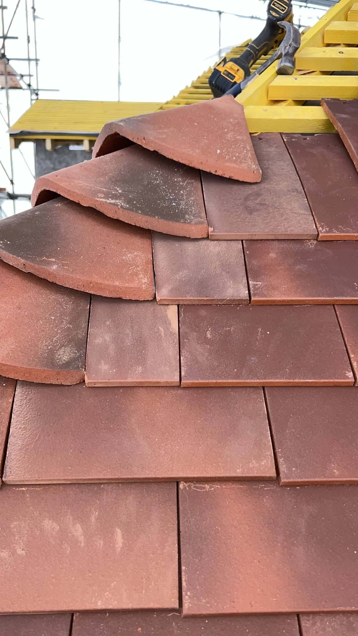 Roofer laying clay tiles on a rebuilt roof in Southgate N14