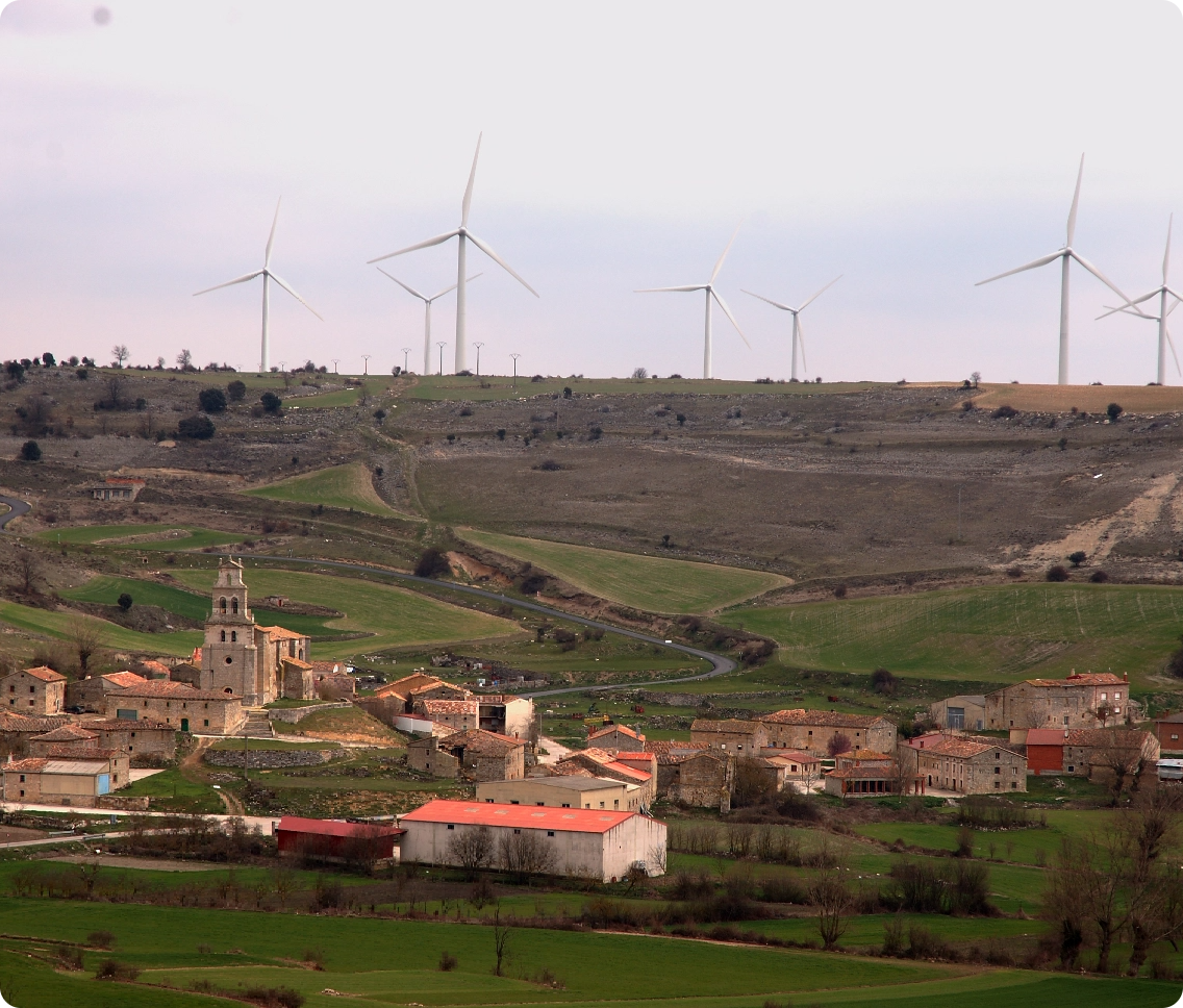 Village and wind turbines in a green valley