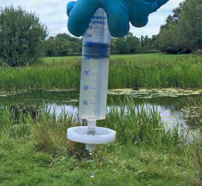 Fishing with eDNA - manual filtration of pond water for conducting a fish survey. Photo credit Kat Bruce.