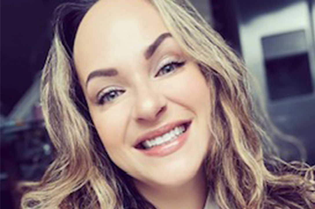 Smiling woman with wavy blonde hair and blue eyes in a close-up selfie.