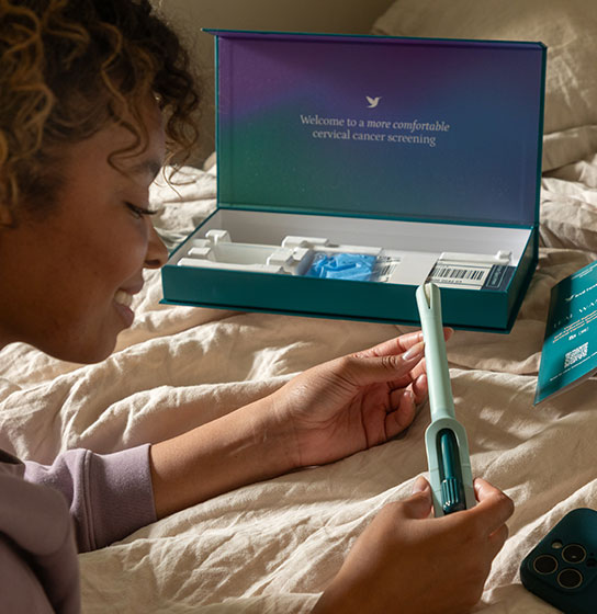 Woman on a bed holding the teal wand by an open kit; caption reads 'Included in the American Cancer Society guidelines.'