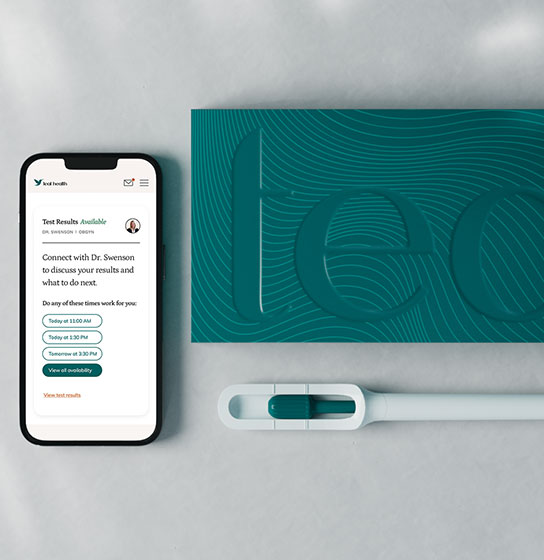 Flat lay of a phone showing a Teal Health 'Test Results Available' screen, a 'teal' box, and the wand.