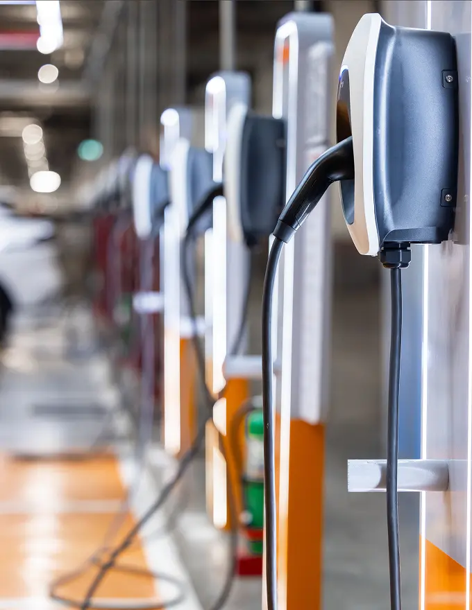 Row of electric vehicle charging stations in a parking garage.