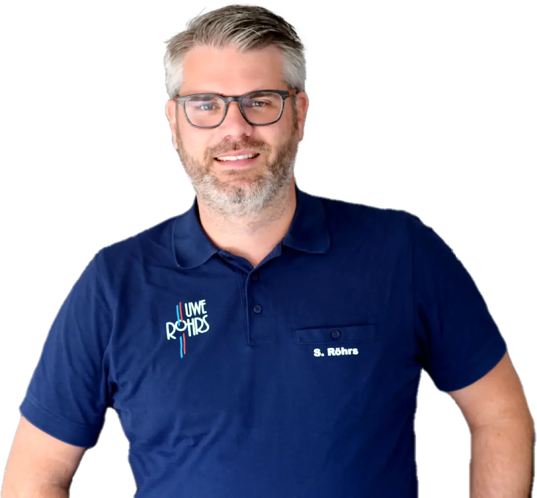 Mann mit Brille und grauem Haar in blauem Poloshirt mit Aufschrift Uwe Röhrs und S. Röhrs.