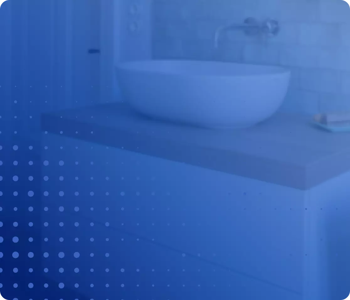 Modernes Badezimmer mit rundem Waschbecken auf grauer Arbeitsplatte und Wandarmatur.