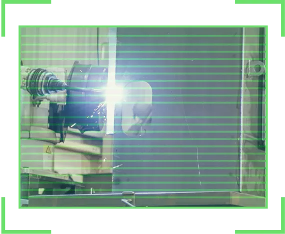 Worker wearing protective gear welding metal with bright sparks and light in an industrial setting.
