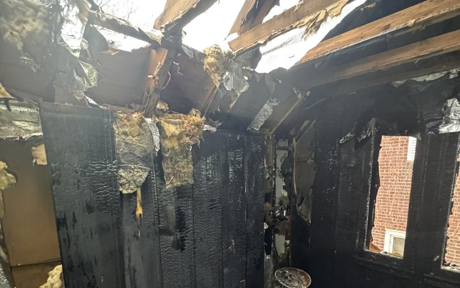 Burned-out upper floor with walls charred through and roof rafters exposed