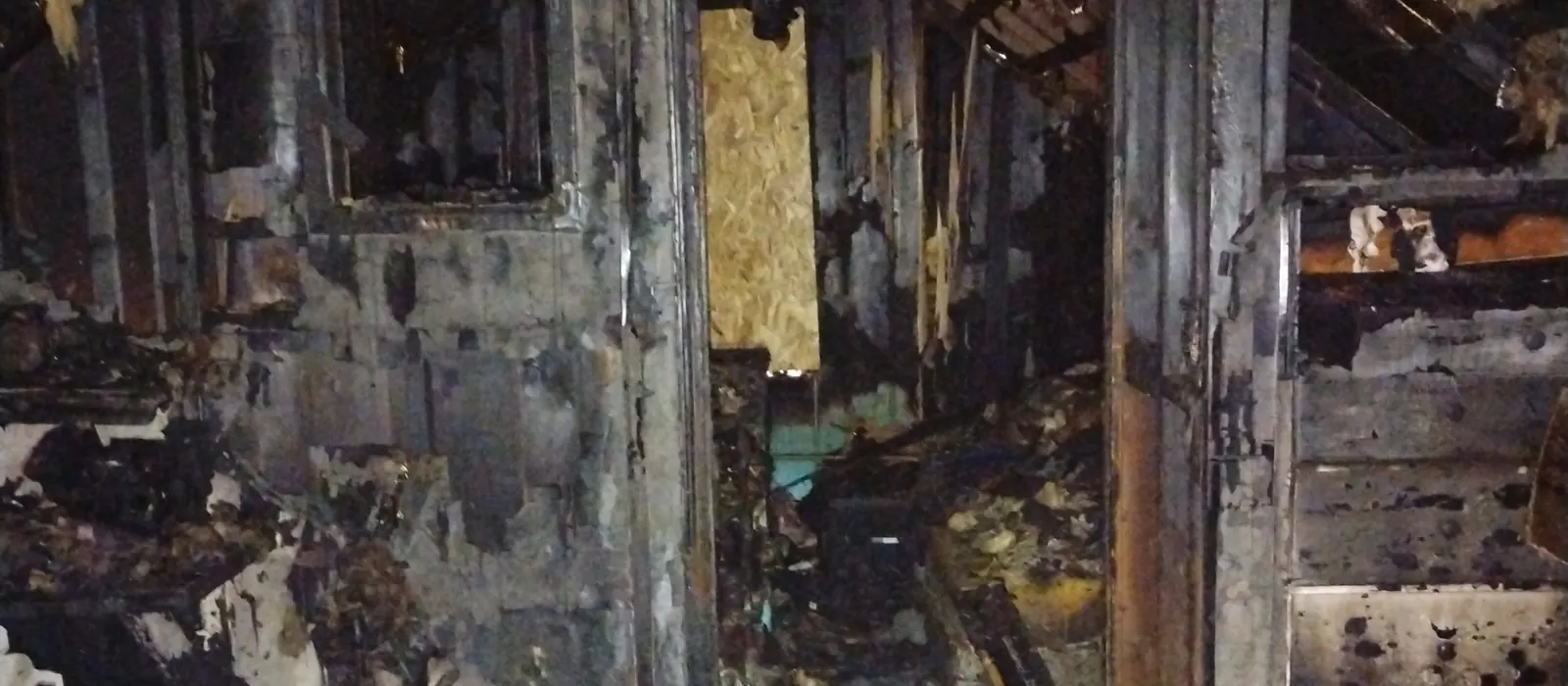Charred walls and door frames inside a fire-damaged room