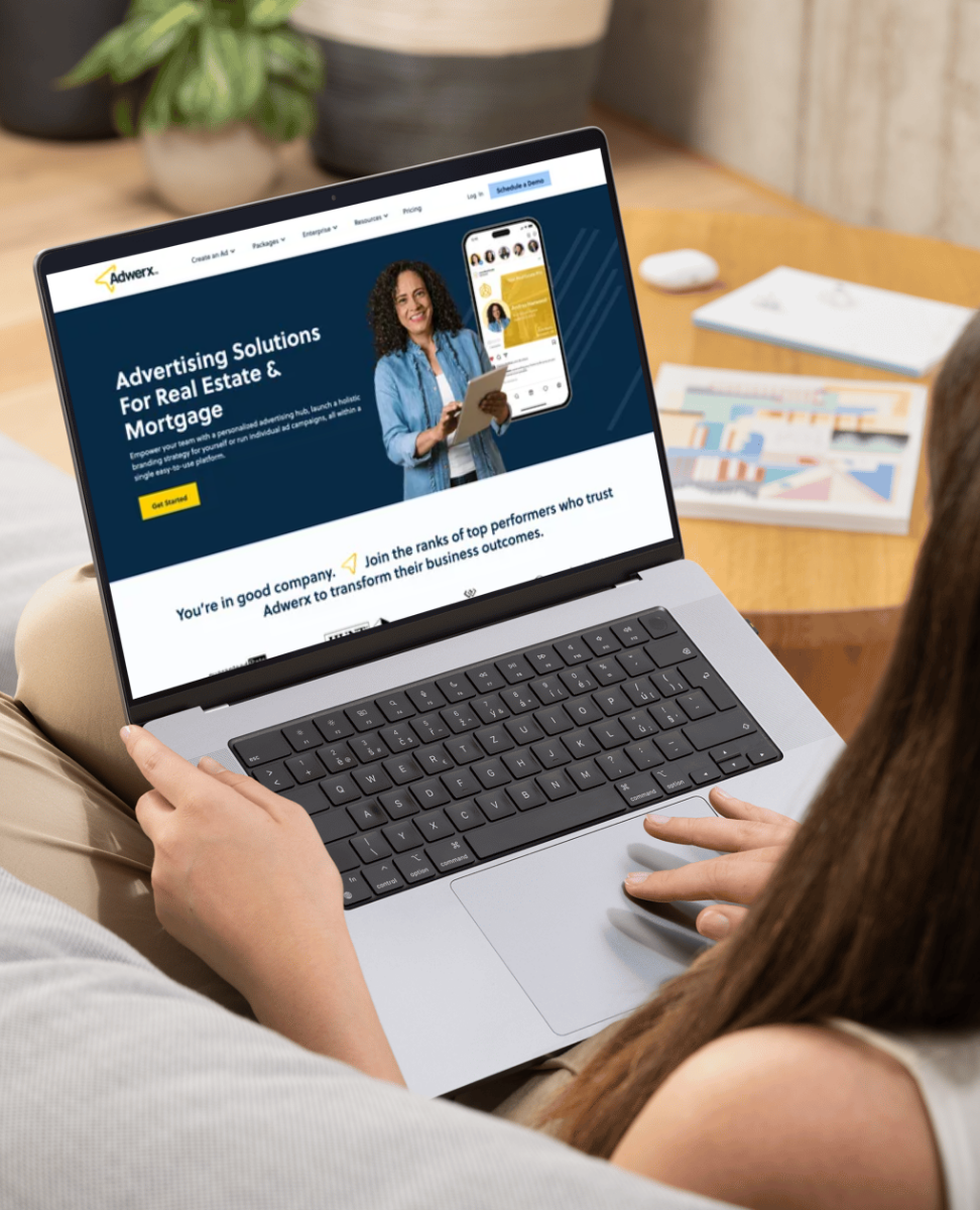 Person using a laptop showing an advertising solutions website for real estate and mortgage.