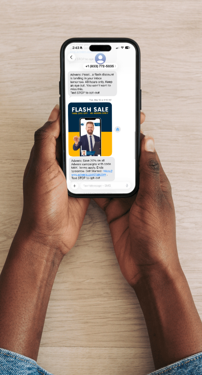 Hands holding smartphone showing a text message with a flash sale discount offer and campaign details.