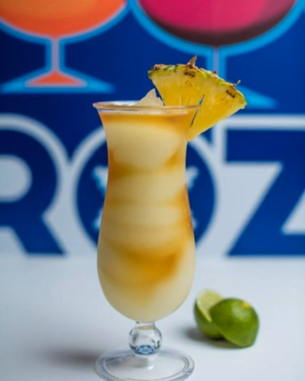 A glass of pineapple juice with a pineapple slice on top.