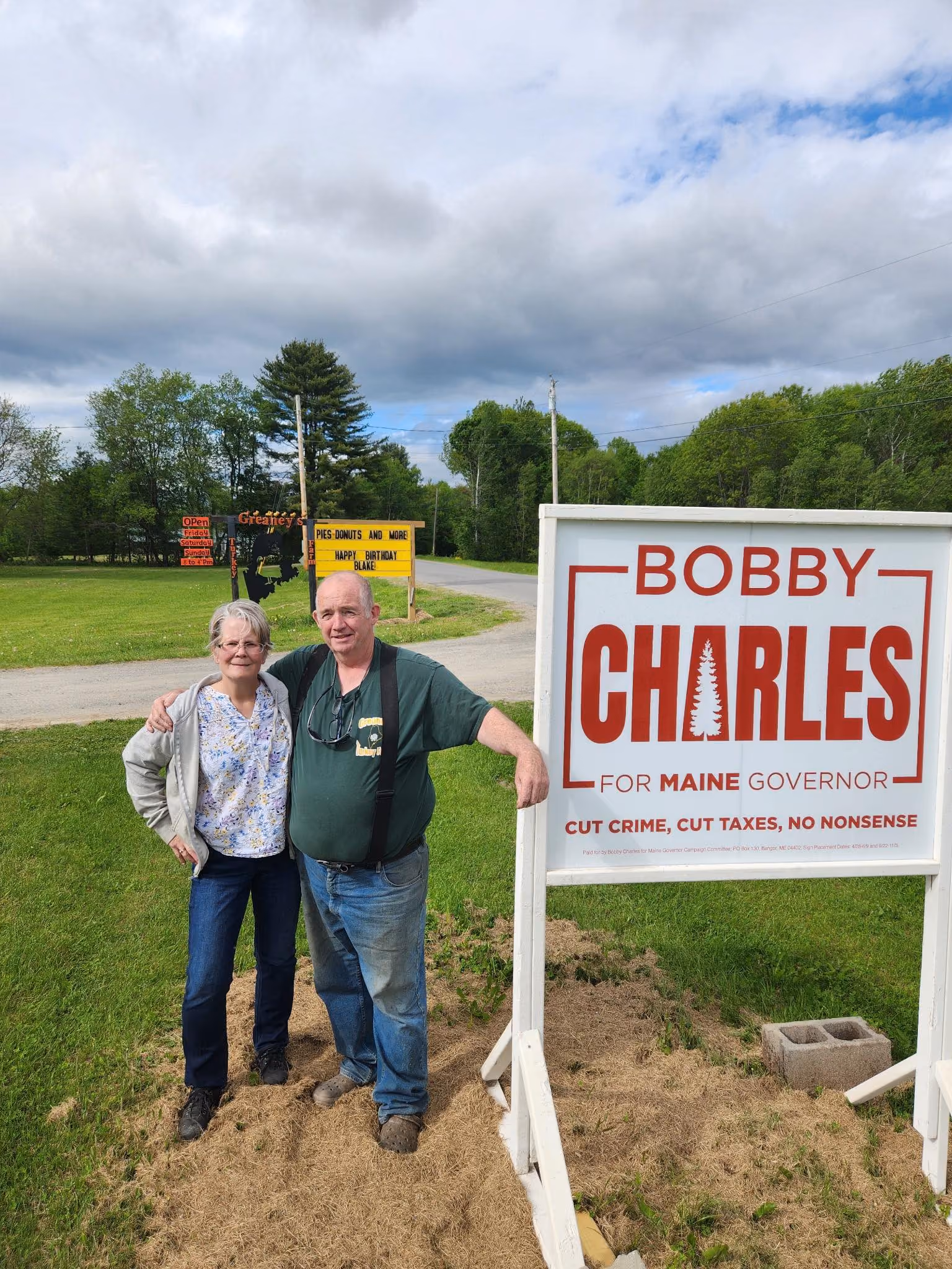 Two people smiling outdoors wearing Dan Franzese for Congress t-shirts and holding campaign flyers.