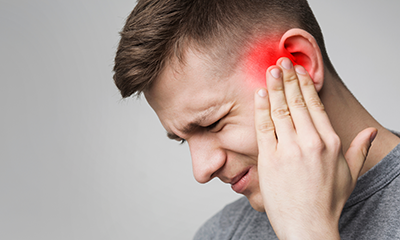 man experiencing severe ear pain