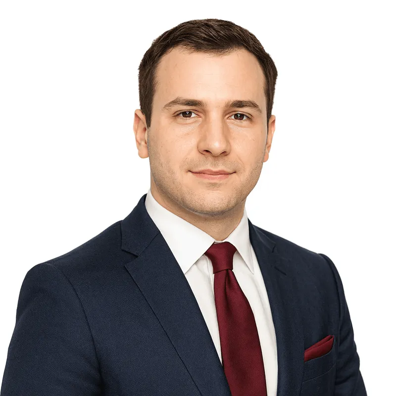 Professional headshot of a man wearing a navy blue suit, white shirt, and burgundy tie with matching pocket square.