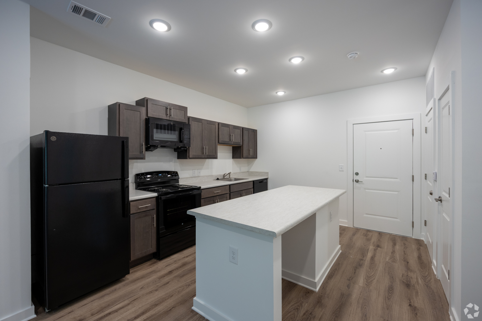 Kitchen with island, brown cabinets and black appliances