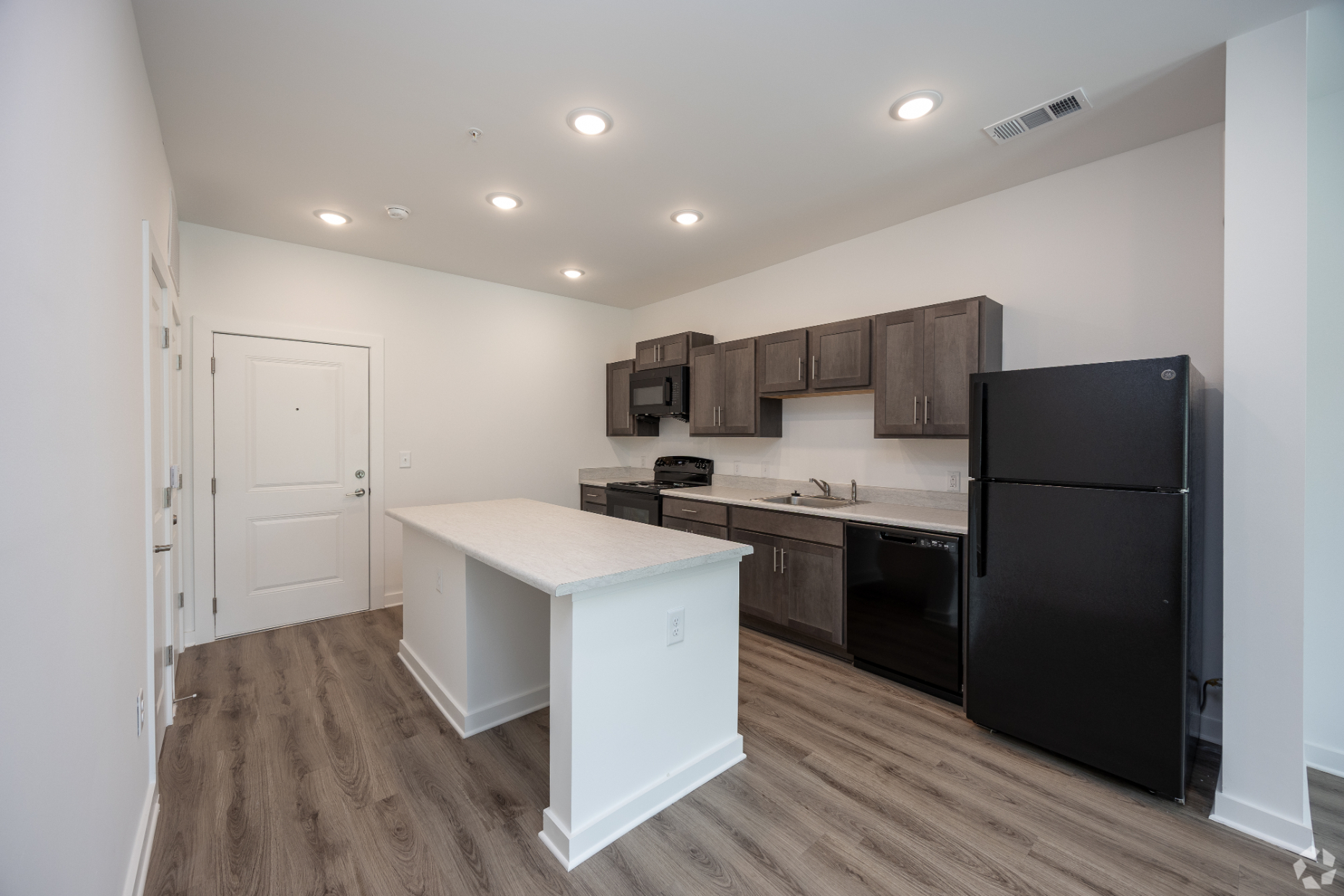 Kitchen with island, brown cabinets and black appliances