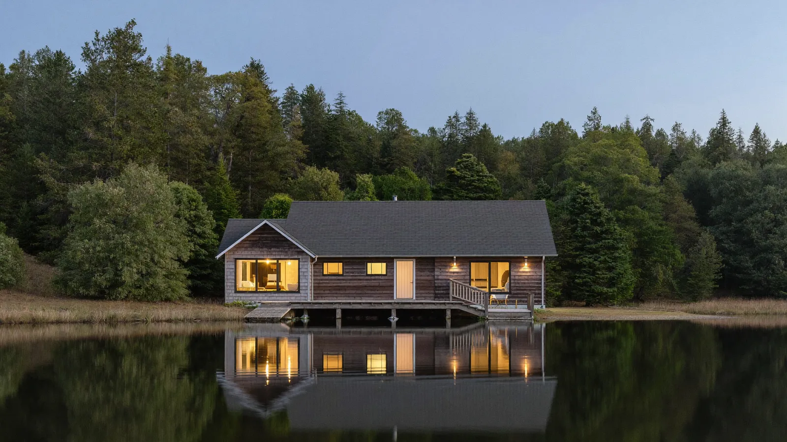 Chalet de bois au bord d'un lac des Laurentides au crépuscule