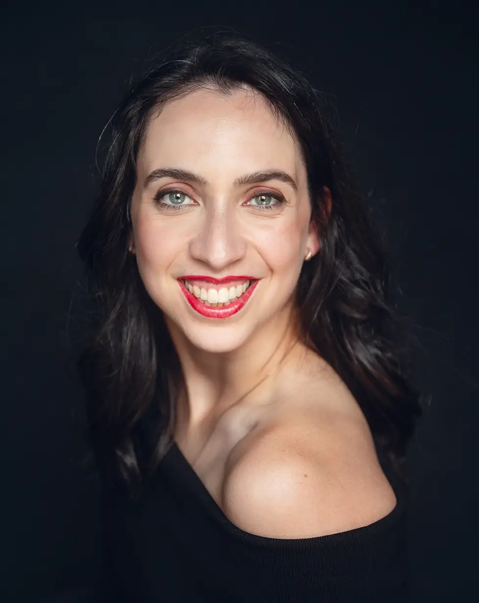 Un portrait rapproché de Martine. Elle regarde par-dessus la caméra de son épaule gauche, avec un sourire chaleureux et un regard bienveillant, prête à mettre ses talents au service de votre événement.**