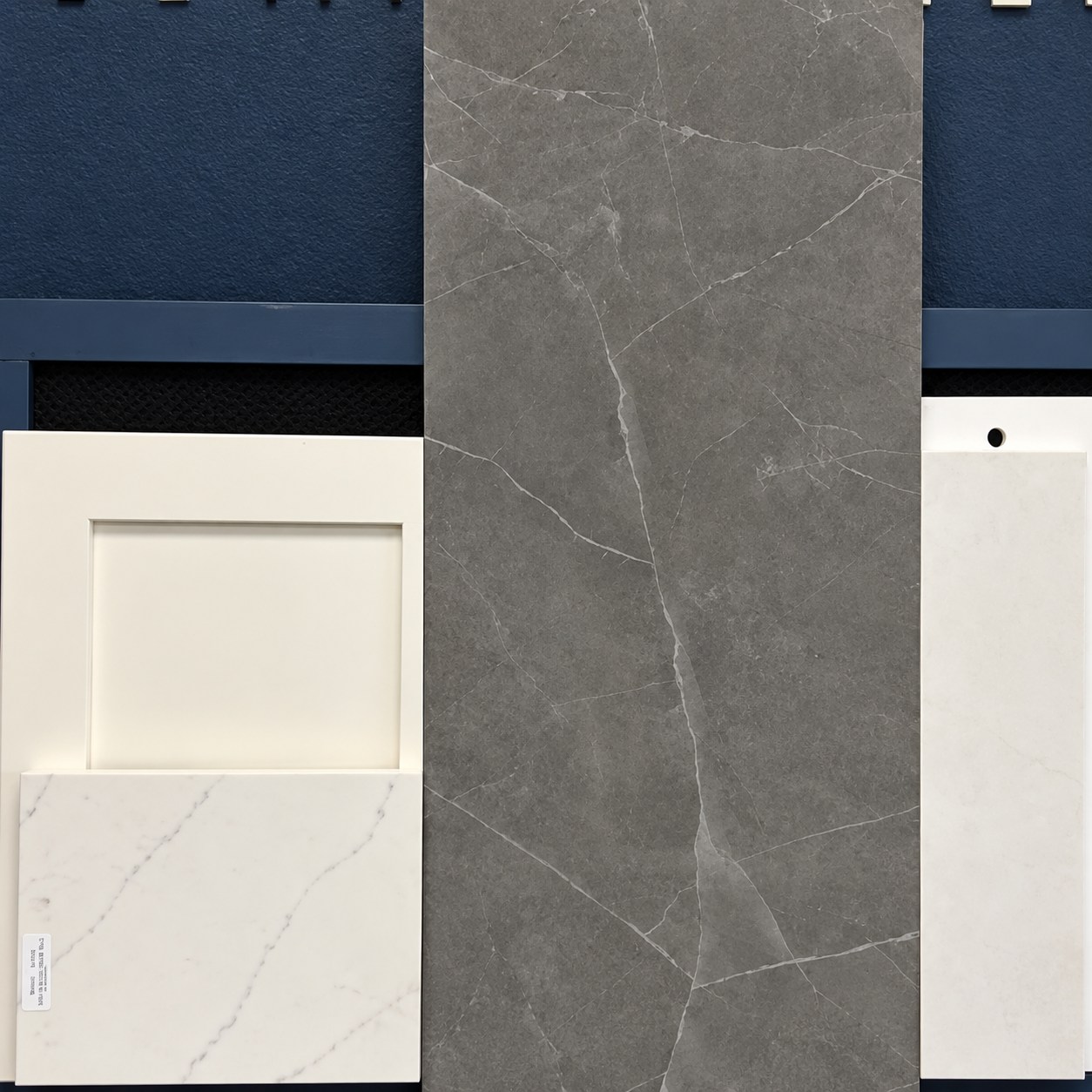 Grey marbled porcelain tile with a white cabinet door and quartz counter sample for the primary bath