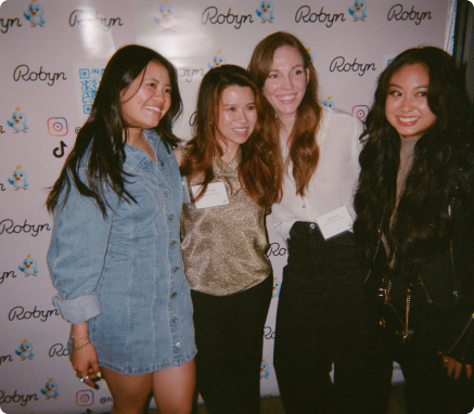 Guests posing at the Robyn launch party step-and-repeat